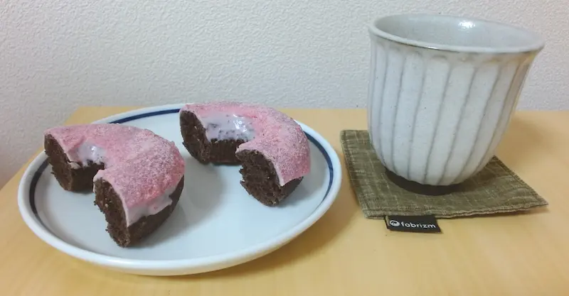 コーヒーと皿に乗っているダブルストロベリーチョコレート ミスタードーナッツ